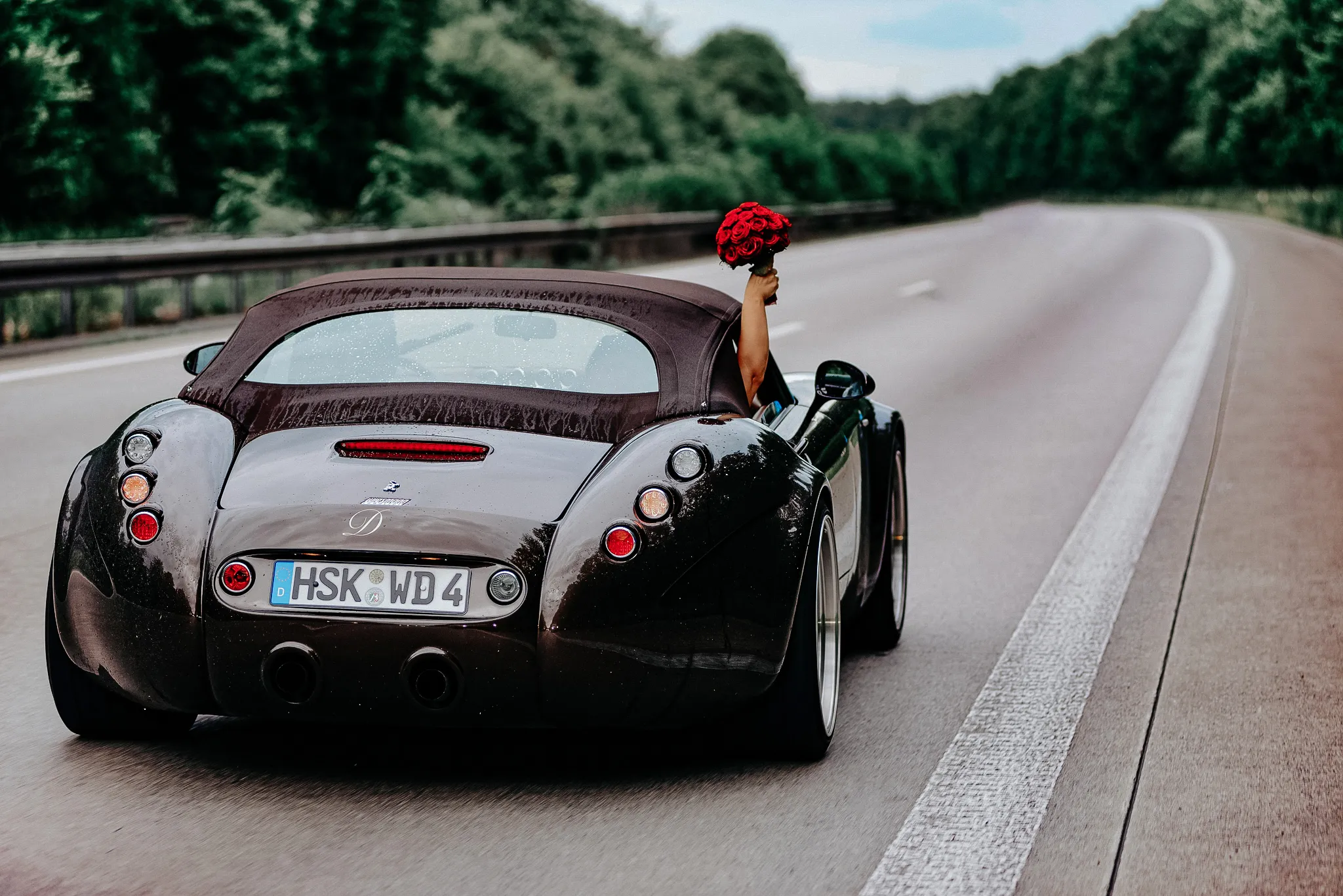 paraa mloda w samochodzie sportowym w trakcie dojazdu na ceremonie sesja zagraniczna w niemczech .pani mloda z bukietem kwiatow